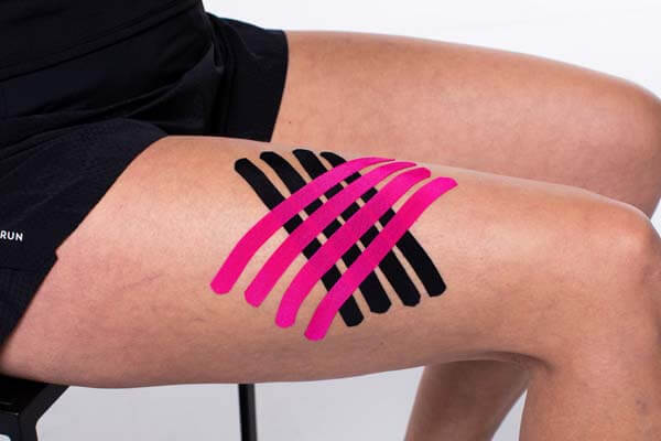 Final result showing black and pink kinesiology tape strips in a criss-cross pattern on the upper thigh.